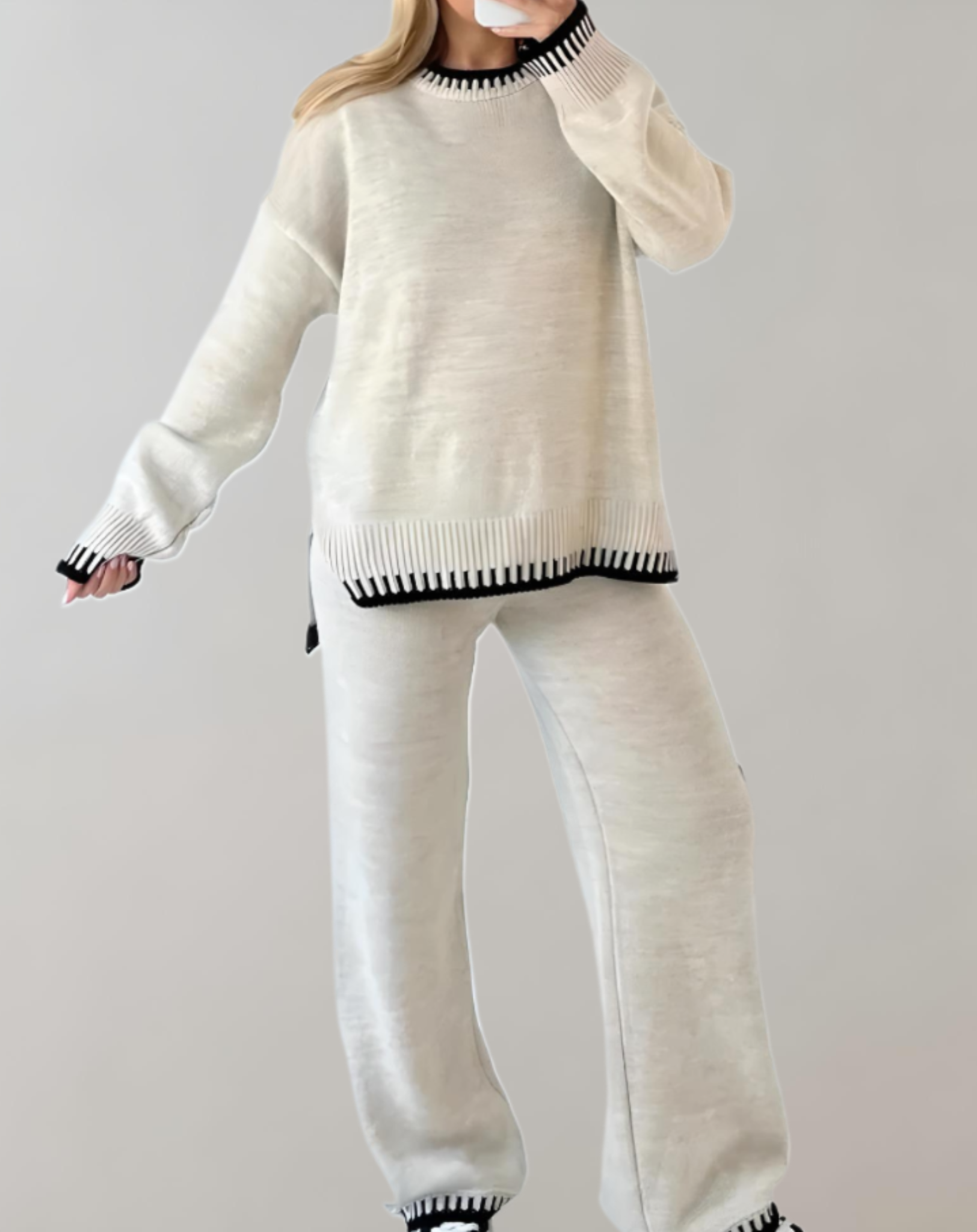 model draagt comfortabele set voor thuis met wijde zachte broek en zachte trui, vrijetijdsset met witte details 