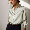 model draagt elegante dames blouse van satijn satijnen blouse met knopen en lange mouwen eest outfit chique