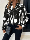 model draagt elegante dames blouse met lange mouwen en print met v-hals